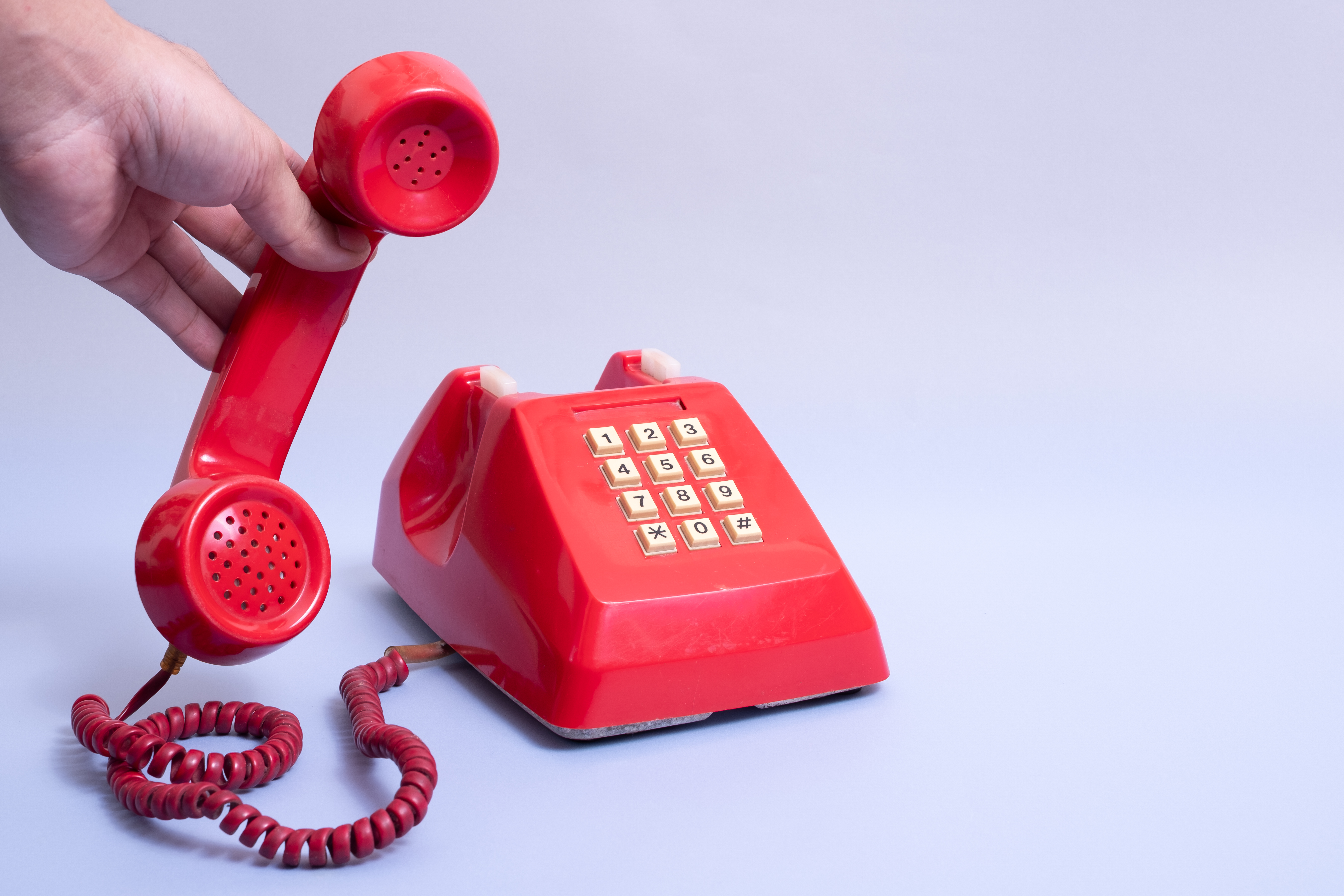 Landline phone with hand white background